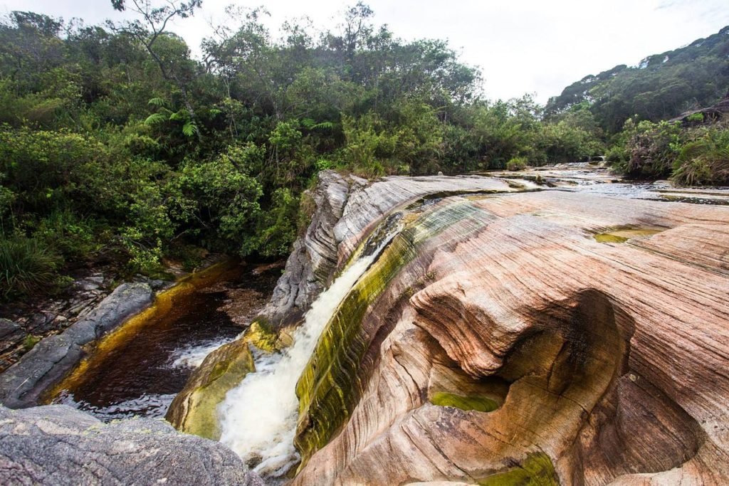 Ducha de cachoeira em Ibitipoca, um dos lugares para viajar em Minas