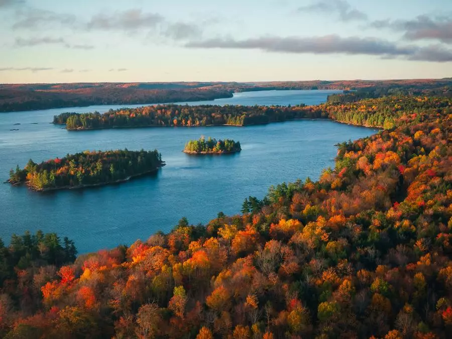 Ontario, província no Canadá, com muitas árvores com folhas alaranjadas e o lago